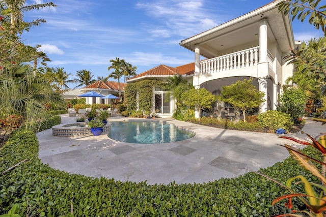 view of swimming pool featuring a patio area and an in ground hot tub