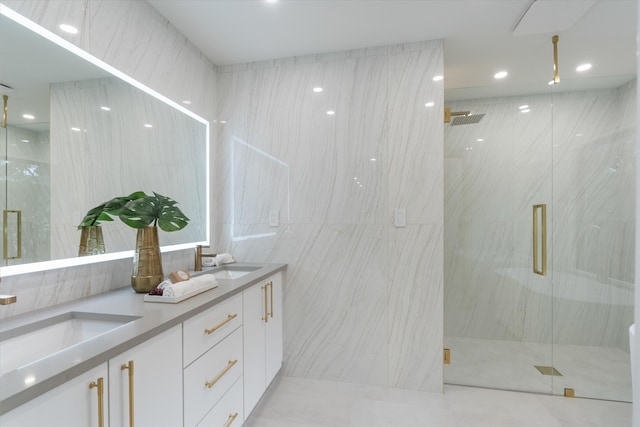 bathroom featuring vanity, a shower with door, and tile walls