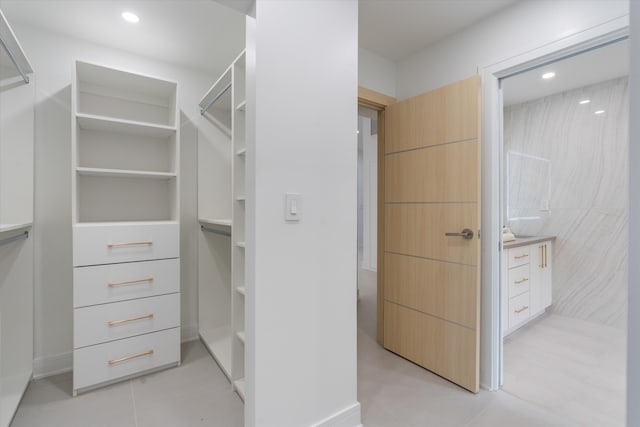 walk in closet with light tile patterned flooring