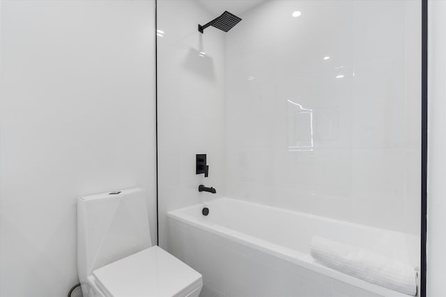 bathroom with tiled shower / bath combo and toilet