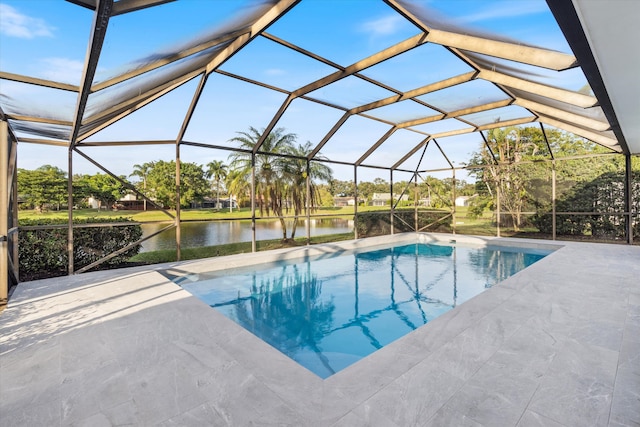 view of pool with glass enclosure, a water view, and a patio