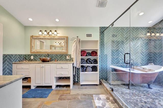 bathroom with a washtub, vanity, and tile walls