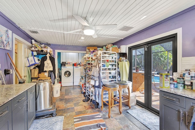 interior space featuring washing machine and clothes dryer, gray cabinets, ceiling fan, and light stone counters