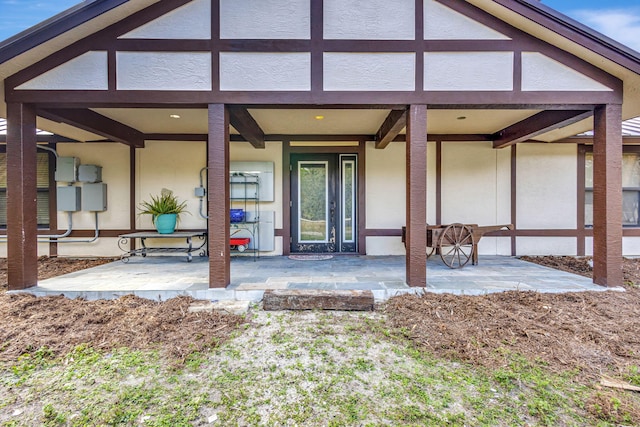 property entrance with a patio area and a wooden deck