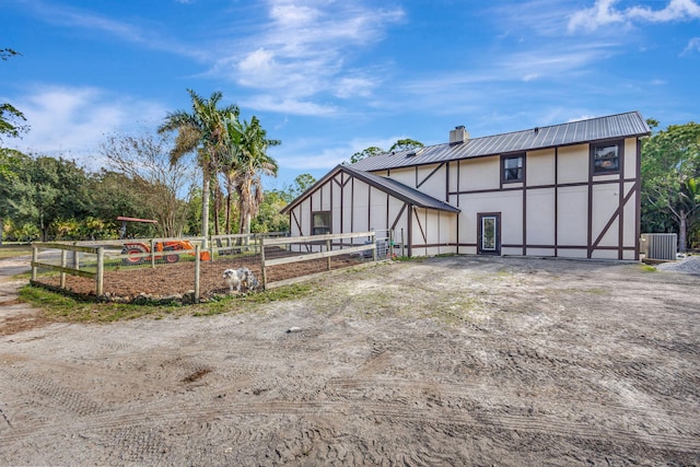 back of property with central AC unit and an outbuilding