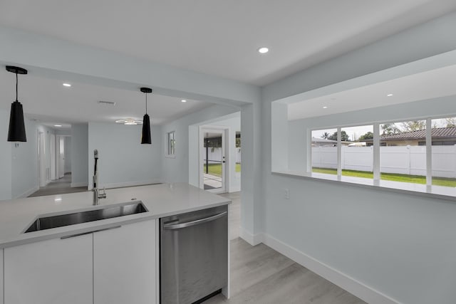 kitchen with dishwasher, sink, pendant lighting, white cabinets, and light wood-type flooring