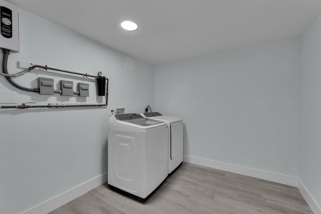 laundry area with washer and clothes dryer and light hardwood / wood-style flooring