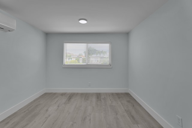 unfurnished room featuring light hardwood / wood-style flooring and a wall mounted AC