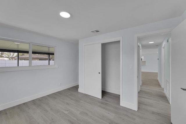 unfurnished bedroom featuring a closet and light wood-type flooring