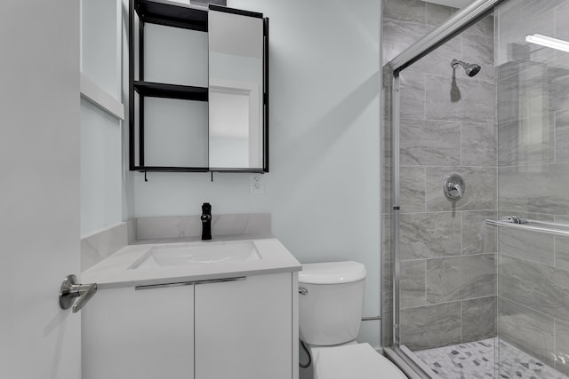 bathroom featuring vanity, toilet, and walk in shower