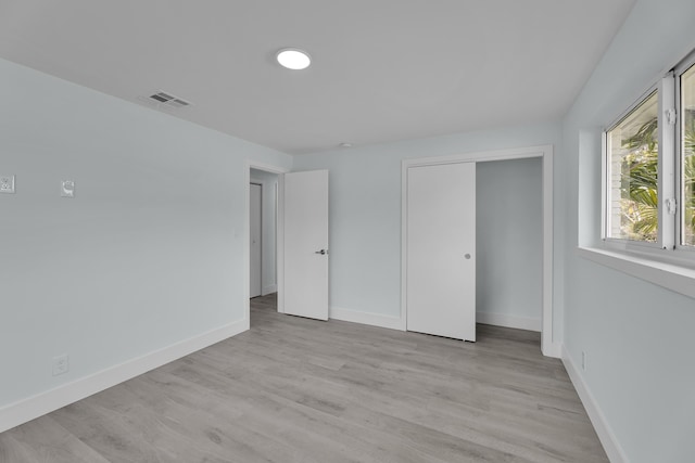 unfurnished bedroom featuring light hardwood / wood-style floors and a closet