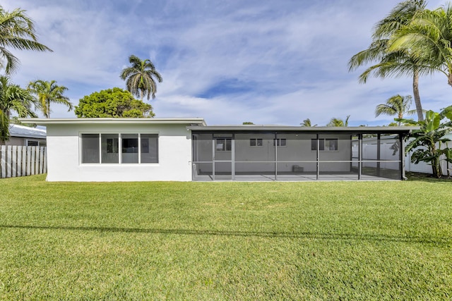 back of house featuring a lawn and a sunroom