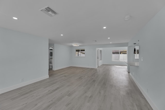 unfurnished living room with a healthy amount of sunlight and light hardwood / wood-style flooring