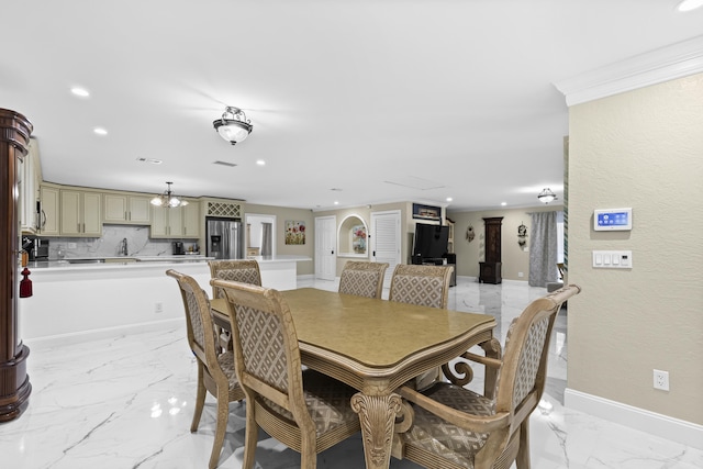 dining area with ornamental molding and a chandelier