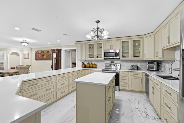 kitchen featuring stainless steel appliances, a center island, decorative backsplash, decorative light fixtures, and cream cabinetry