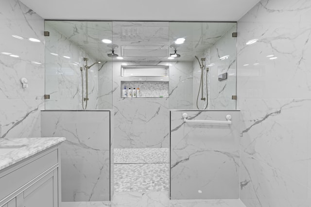 bathroom with a tile shower and vanity