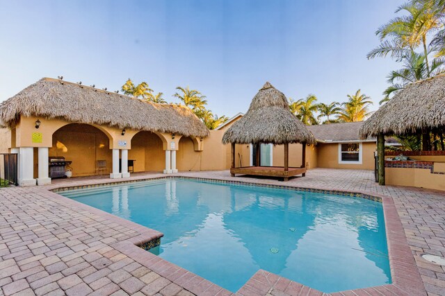 view of swimming pool with a grill, exterior kitchen, and a patio area