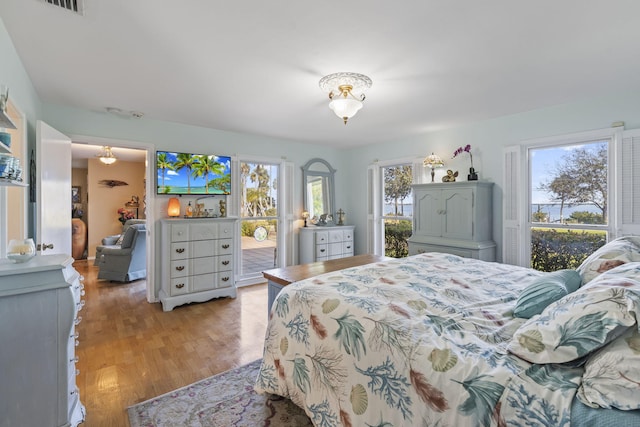 bedroom with light hardwood / wood-style floors, multiple windows, and access to exterior