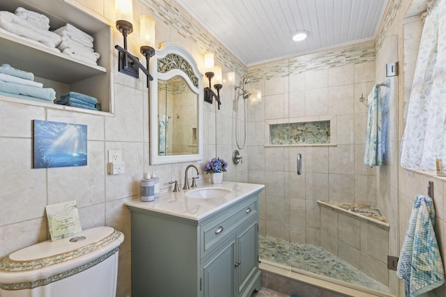 bathroom featuring tile walls, a shower with shower door, toilet, vanity, and crown molding