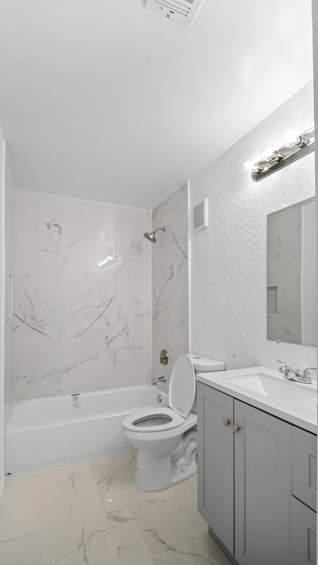 full bathroom with tiled shower / bath combo, vanity, and toilet