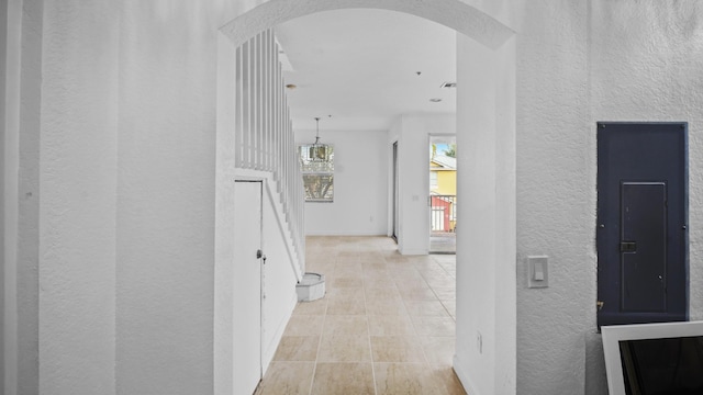 corridor with light tile patterned floors and electric panel