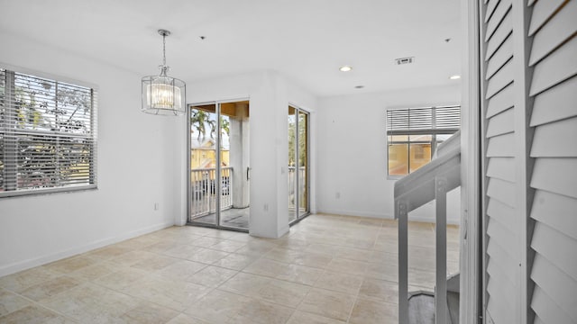 unfurnished room featuring a healthy amount of sunlight and a notable chandelier