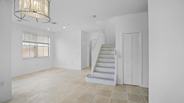 stairway with a notable chandelier