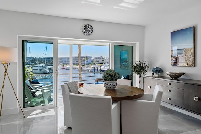 dining space featuring a wealth of natural light and a water view