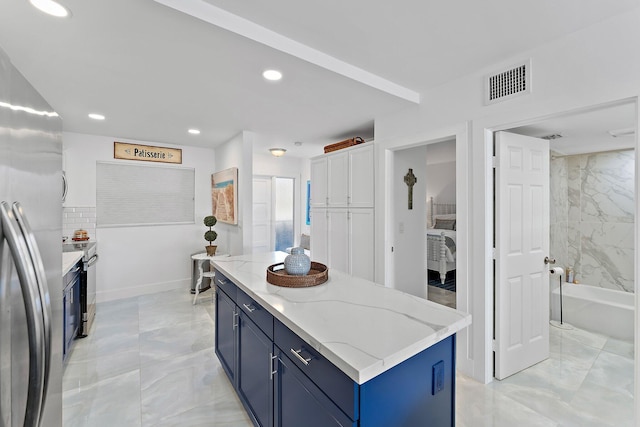 kitchen featuring a center island, white cabinetry, light stone countertops, stainless steel appliances, and blue cabinets