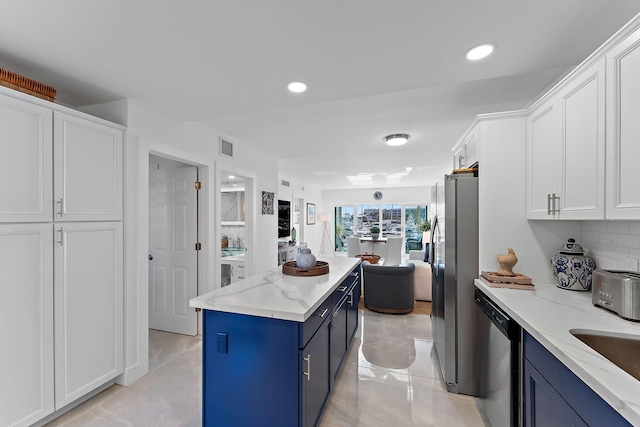 kitchen featuring backsplash, white cabinetry, light stone countertops, appliances with stainless steel finishes, and blue cabinets