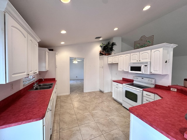 kitchen featuring sink, white cabinets, vaulted ceiling, white appliances, and light tile patterned floors