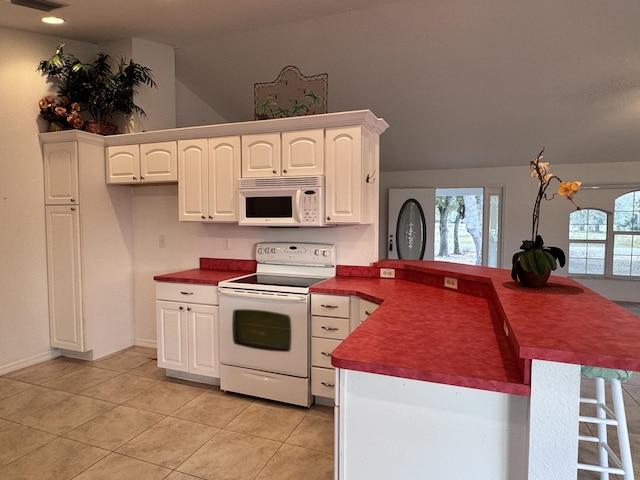 kitchen featuring white appliances, light tile patterned floors, white cabinets, and kitchen peninsula