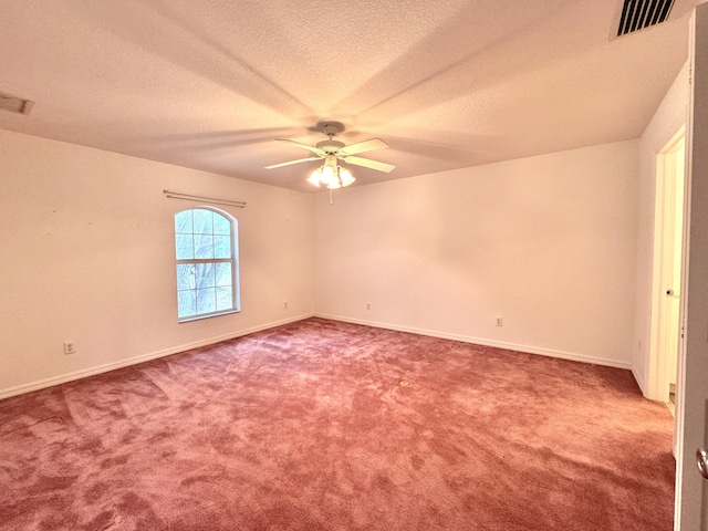 carpeted empty room featuring ceiling fan and a textured ceiling