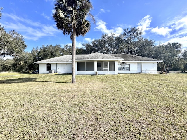 rear view of house featuring a yard and a sunroom