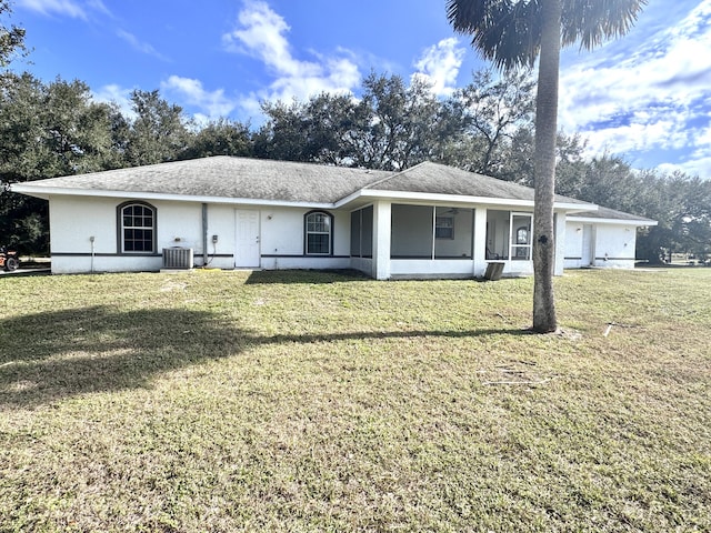 ranch-style house with a front lawn, cooling unit, and a garage