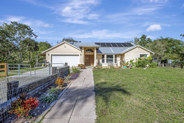 single story home with solar panels, a garage, and a front yard