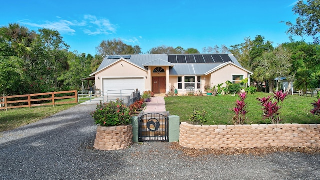 view of front facade with solar panels, a front yard, and a garage