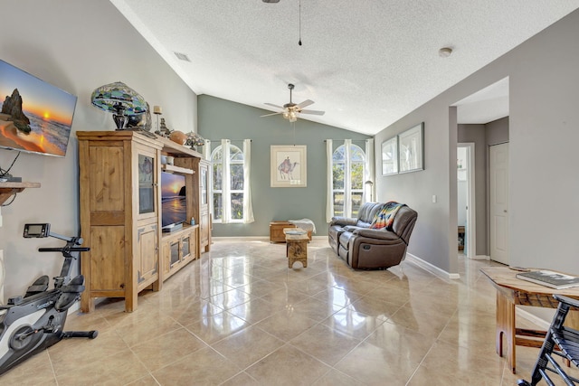 interior space featuring ceiling fan, lofted ceiling, and a textured ceiling