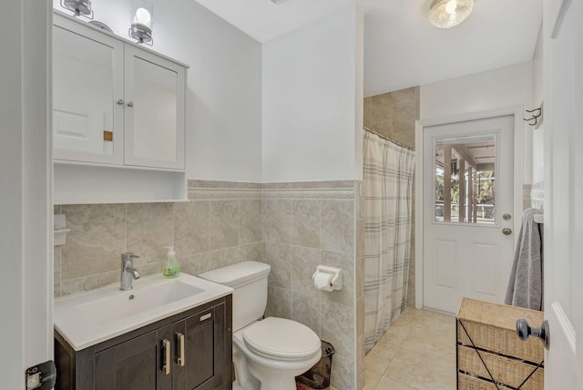 bathroom featuring vanity, tile patterned flooring, toilet, tile walls, and walk in shower