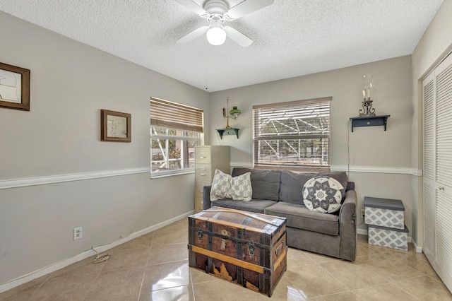 tiled living room featuring a textured ceiling and ceiling fan