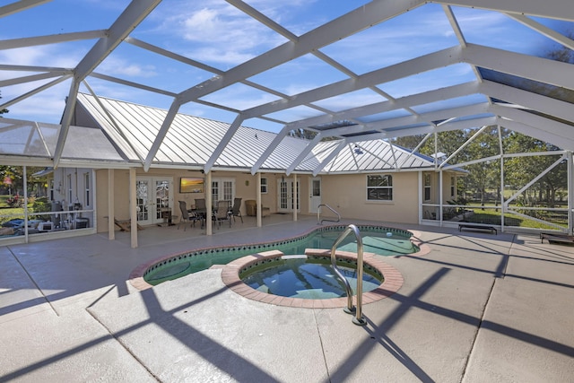 view of swimming pool with a patio area, a lanai, an in ground hot tub, and french doors