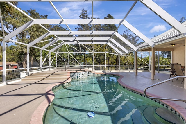 view of pool featuring glass enclosure, a patio area, and an in ground hot tub