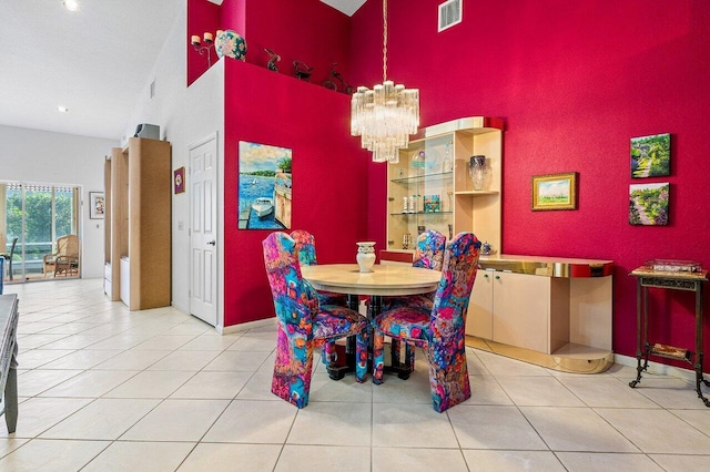 dining space featuring light tile patterned floors, a high ceiling, and an inviting chandelier