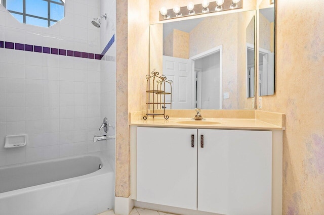 bathroom with tiled shower / bath combo, tile patterned flooring, and vanity