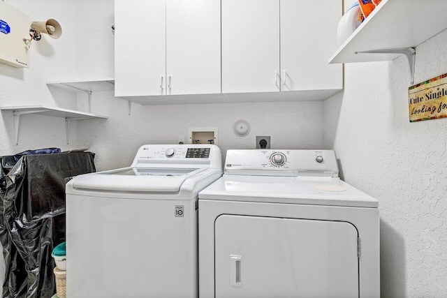 laundry room featuring washer and clothes dryer and cabinets