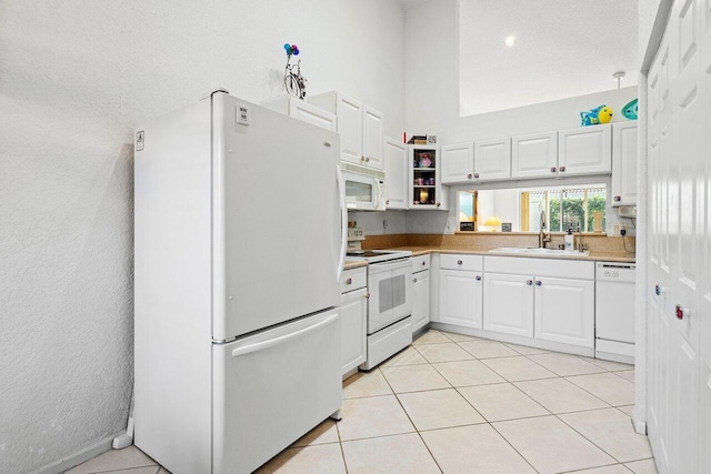 kitchen featuring sink, white appliances, white cabinetry, and light tile patterned flooring