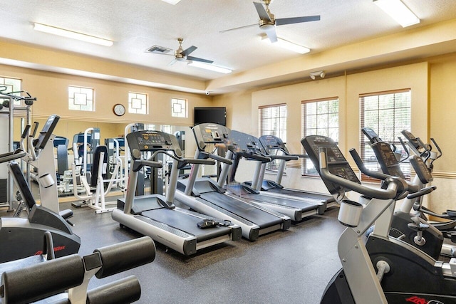 exercise room with a textured ceiling and ceiling fan