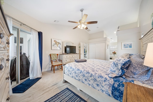 carpeted bedroom with multiple windows, a closet, vaulted ceiling, and ceiling fan