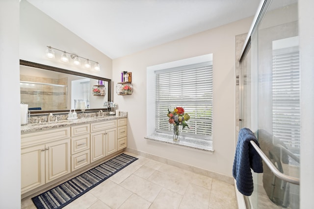 bathroom with tile patterned flooring, vanity, a shower with shower door, and lofted ceiling