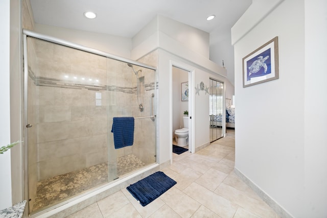 bathroom featuring tile patterned floors, toilet, and an enclosed shower